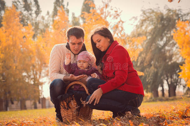 快乐的年轻家庭在秋天的公园里度<strong>过户</strong>外时光