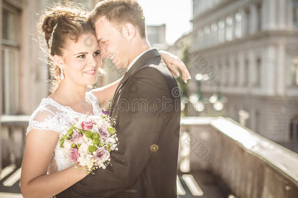 年轻幸福的新婚夫妇新娘在婚礼当天遇到新郎。幸福的新婚夫妇在阳台上欣赏美丽的景色。