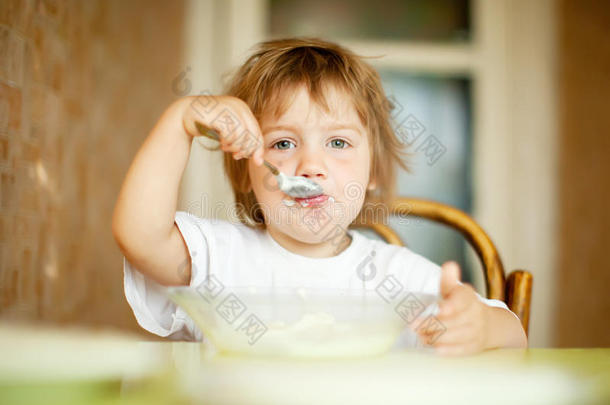 孩子用勺子从盘子里<strong>吃东西</strong>