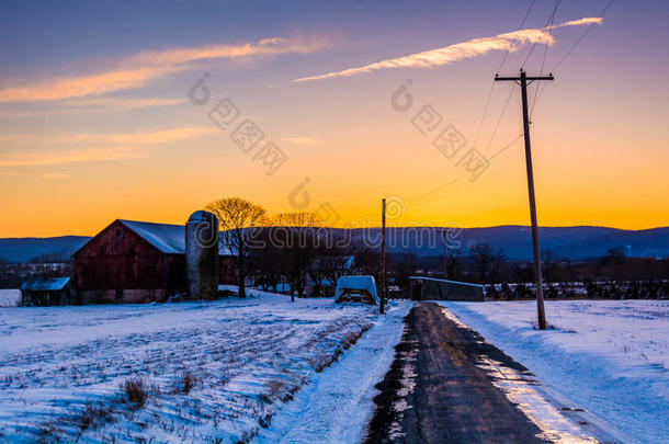 马里兰州弗雷德里克县农村公路上的谷仓和雪覆盖着田野。