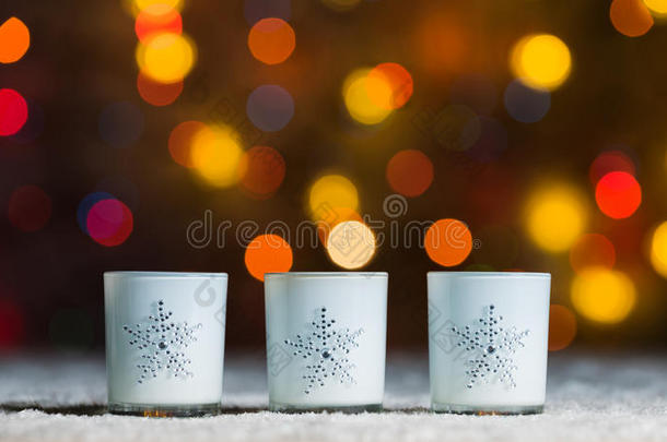 站在雪中的蜡烛，背景是橙色或金色的灯罩
