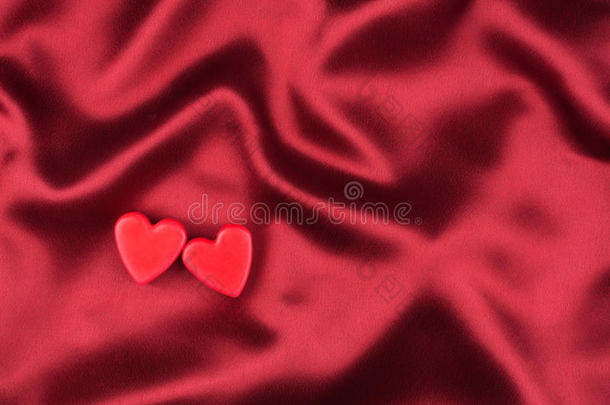 两个情人的心躺在红绸缎上的概念