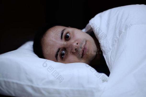 一个失眠症患者躺在床上的画像