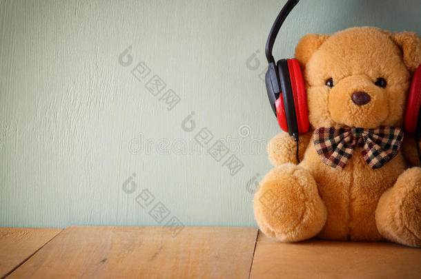 木桌上戴着耳机的泰迪熊