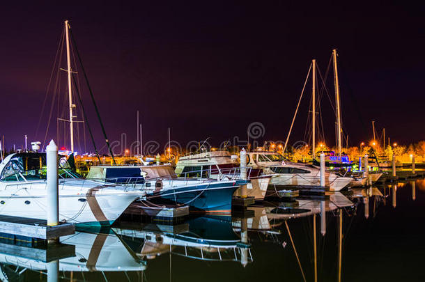 在肯特岛的一个码头上，夜晚的船在水面上反射