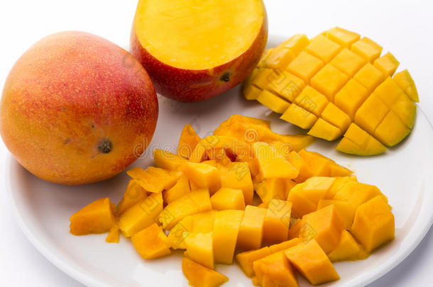 盘子里放一堆多汁的芒果块和整个水果