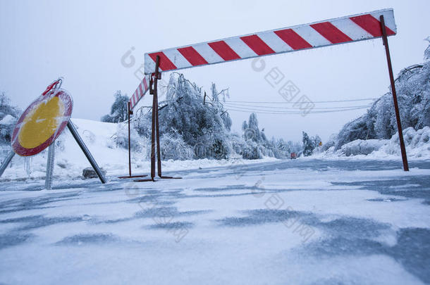 自然<strong>灾害</strong>：由于雨夹雪，道路因结冰而封闭，背景是倒下的树木