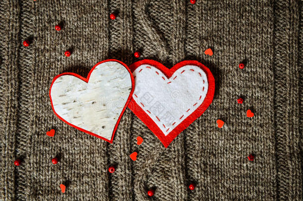 温暖针织背景上的手工心形装饰。情人节概念。手工心形复古卡片。