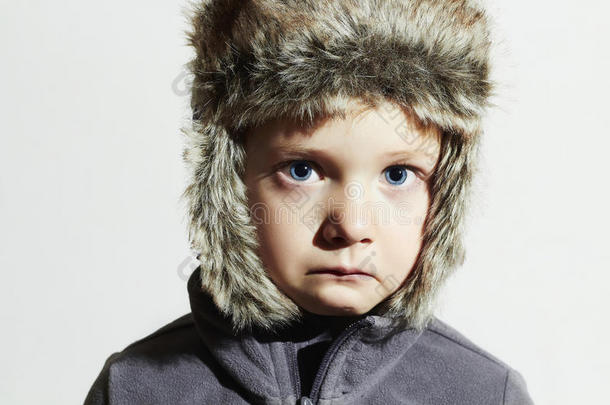 穿皮草的可怜的孩子帽子。孩子们不经意的冬天风格。小孩子们情感