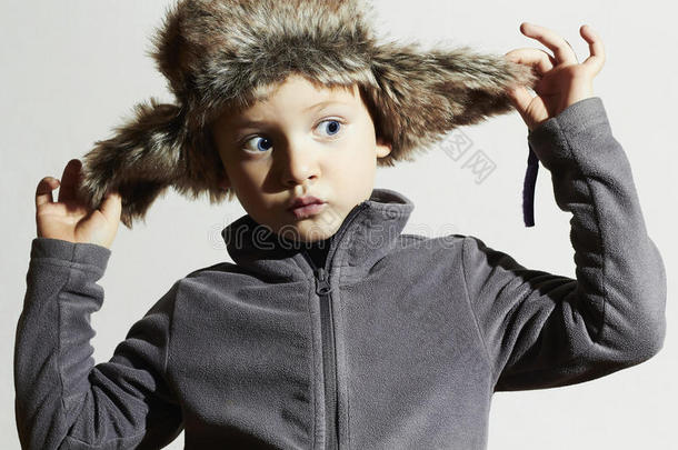 穿皮草的滑稽小孩帽子。孩子们时尚休闲冬季风格。小孩子们情感