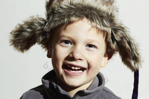 穿着皮草微笑的孩子帽子。孩子们不经意的冬天时尚。时尚有点好笑孩子们情感