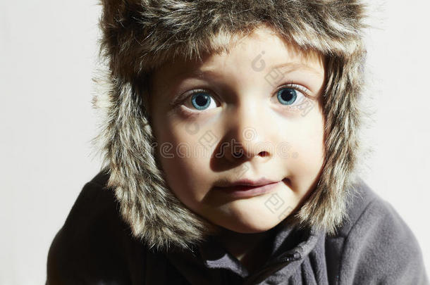 穿皮草的滑稽小孩帽子。休闲冬天风格。大蓝眼睛