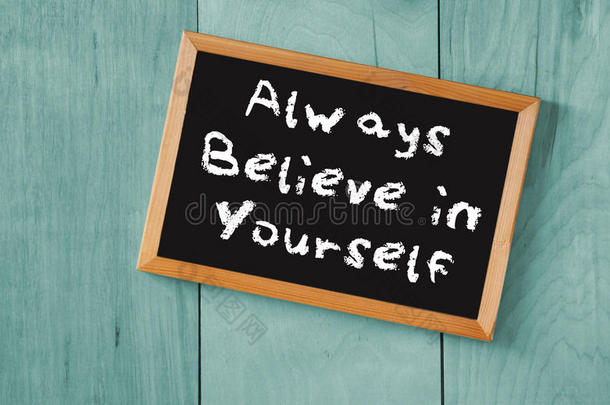在木制背景上，用“永远相信你自己”这句话作为黑板的顶视图