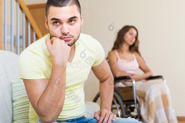 伤感的男人和女友坐在无效的椅子上