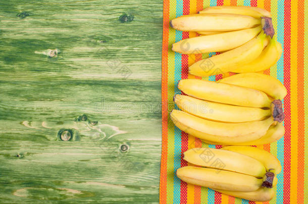 香蕉放在一块绿色的黑板上，放在彩色餐巾纸上