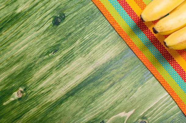 香蕉放在一块绿色的黑板上，放在彩色餐巾纸上