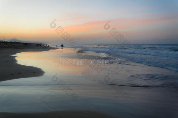 夏日的日落在几乎空无一人的西班牙地中海海滩上