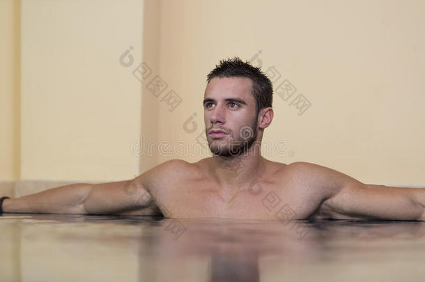 男子在游泳池边上放松地休息