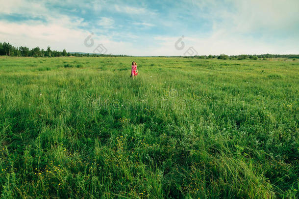快乐的小女孩走在夏日的草地上