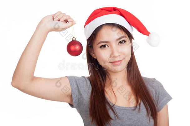 <strong>戴</strong>着红色圣诞帽的亚洲女孩拿着<strong>饰品</strong>微笑着