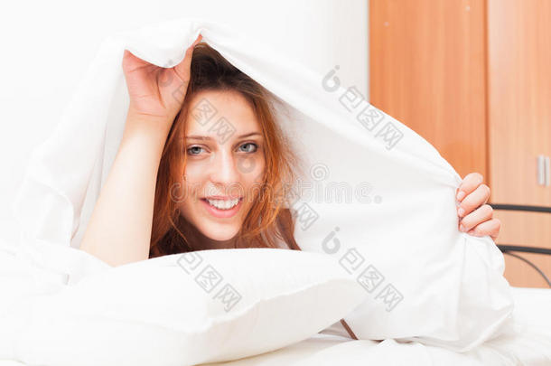 红发女人在家里躺在床上用白<strong>床单</strong>醒来