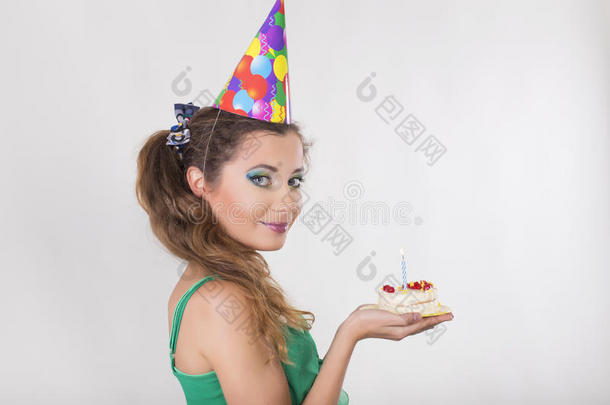 戴着<strong>生日帽</strong>的女人吹着蛋糕上的蜡烛