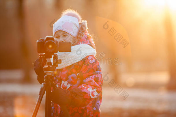 儿童摄影师使用三脚架、落日光、复印空间在相机上拍照