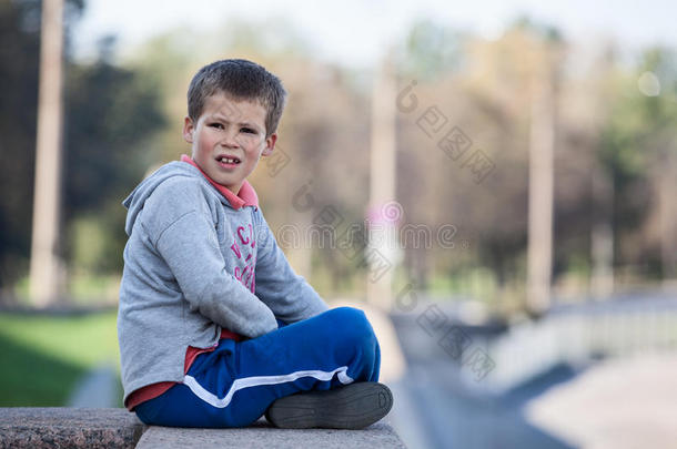 可爱的男孩坐在花岗岩路缘上的莲花位置，复制区
