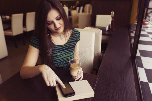 黑发女人坐在咖啡馆看书学习喝咖啡等待迟到