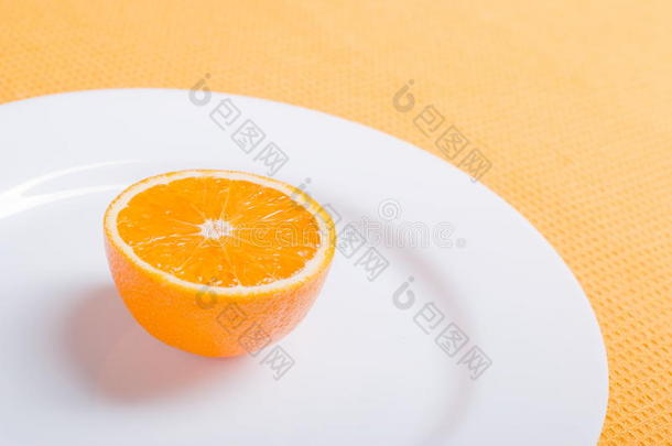 在黄色餐巾上的白色盘子上切好的开胃橘子片