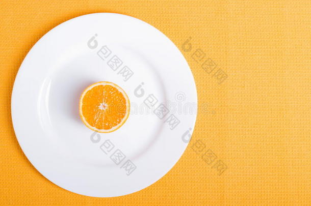 在黄色餐巾上的白色盘子上切好的开胃橘子片