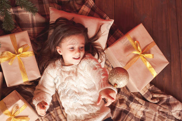 圣诞<strong>树下</strong>拿着圣诞礼物的小女孩