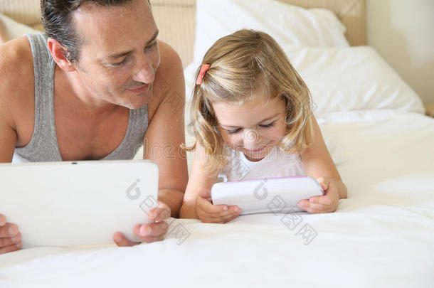 父女俩一起玩平板电脑游戏