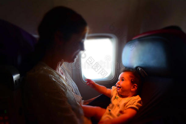 母亲在飞机上抱着她的婴儿