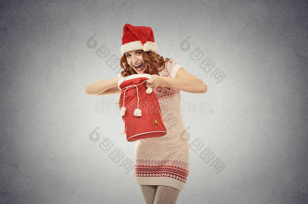 戴圣诞老人红帽子的圣诞妇女拿着<strong>打开</strong>的<strong>礼包</strong>