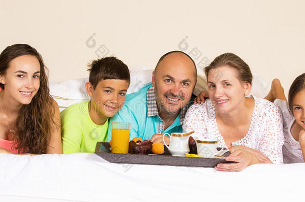 快乐的微笑快乐的一家人在床上吃早餐