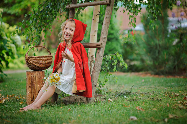可爱快乐的小女孩在夏日花园里玩<strong>小红帽</strong>