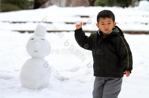 打雪仗和堆雪人的日本男孩