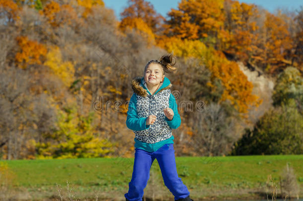 在阳光明媚、<strong>绚丽</strong>多姿的日子里，快乐的小女孩在秋天的公园里跳舞