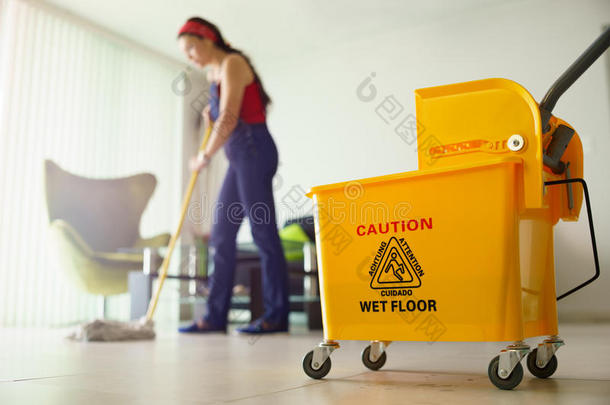 做家务的女人在家打扫地板把注意力集中在水桶上