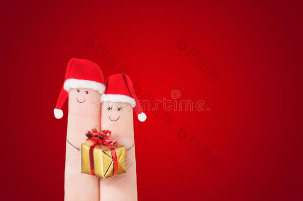 手指脸在圣诞帽和<strong>礼品</strong>盒在深<strong>红色背景</strong>