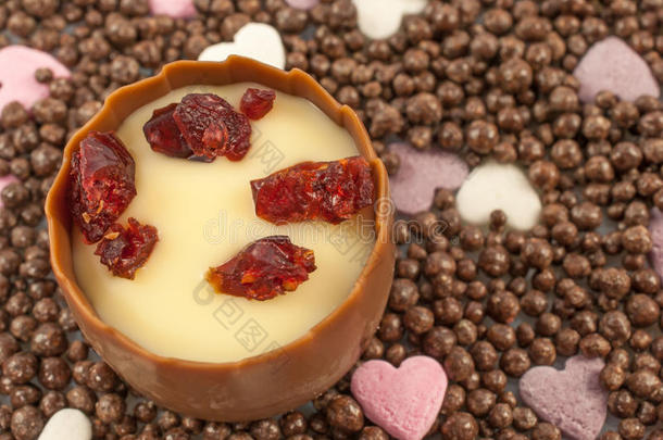 光滑的牛奶巧克力和芳香的樱桃白兰地松露中心，装饰有甜干蔓越莓片