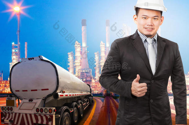 戴着安全帽的年轻工程师站在重石化炼油厂美丽的灯光下