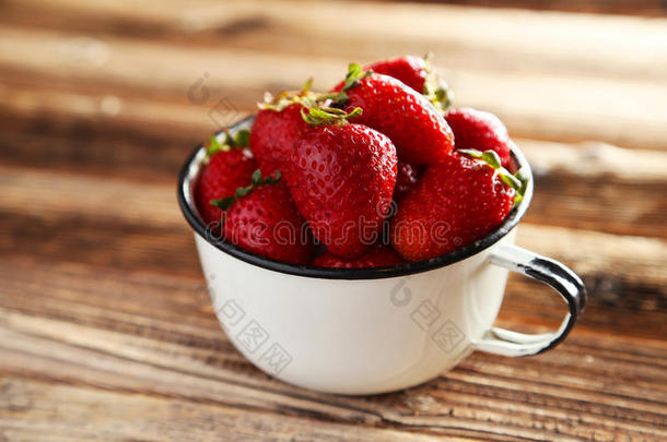 <strong>咖啡色</strong>木质背景的杯中草莓