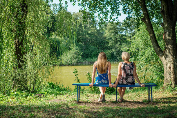 夏天，两个不<strong>同年</strong>代的女人坐在池塘边的长凳上。母女拥抱。奶奶和奶奶