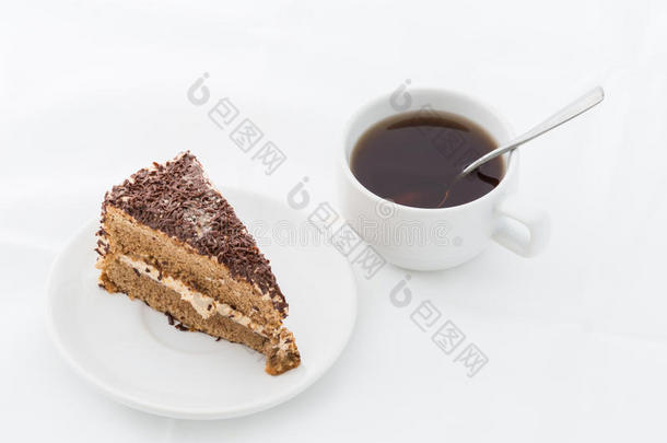 巧克力蛋糕片与卷曲在白色盘子与热饮料