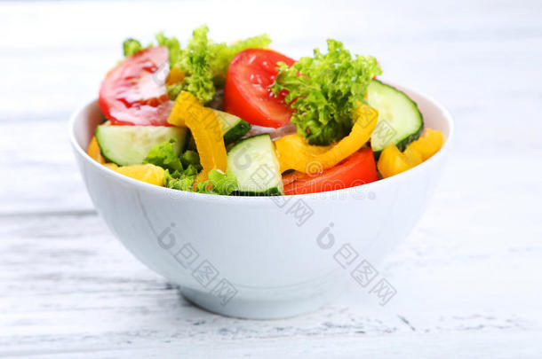 白色木制背景的新鲜蔬菜沙拉