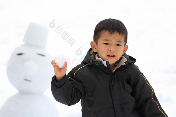 打雪仗和堆雪人的日本男孩