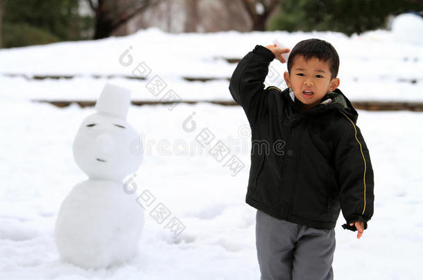 打雪仗和堆雪人的日本男孩