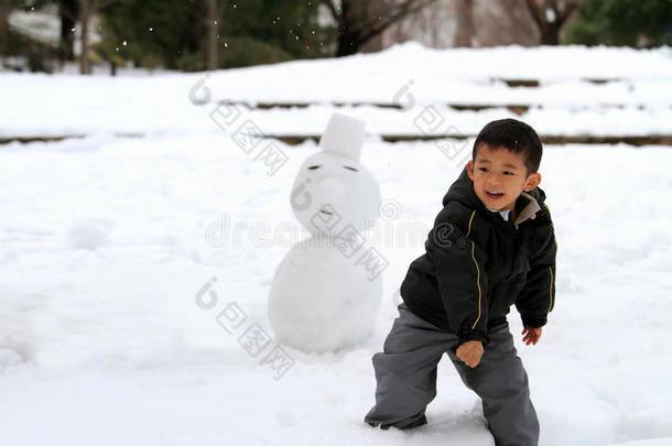 打雪仗和堆雪人的日本男孩